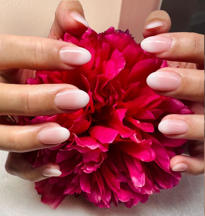 Baby Boomer hands with beautiful nails Baby Boomer style holding a big red flower